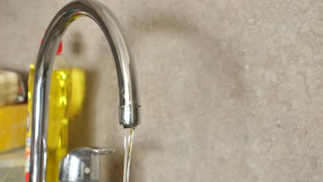 agua que fluye de un grifo de la cocina