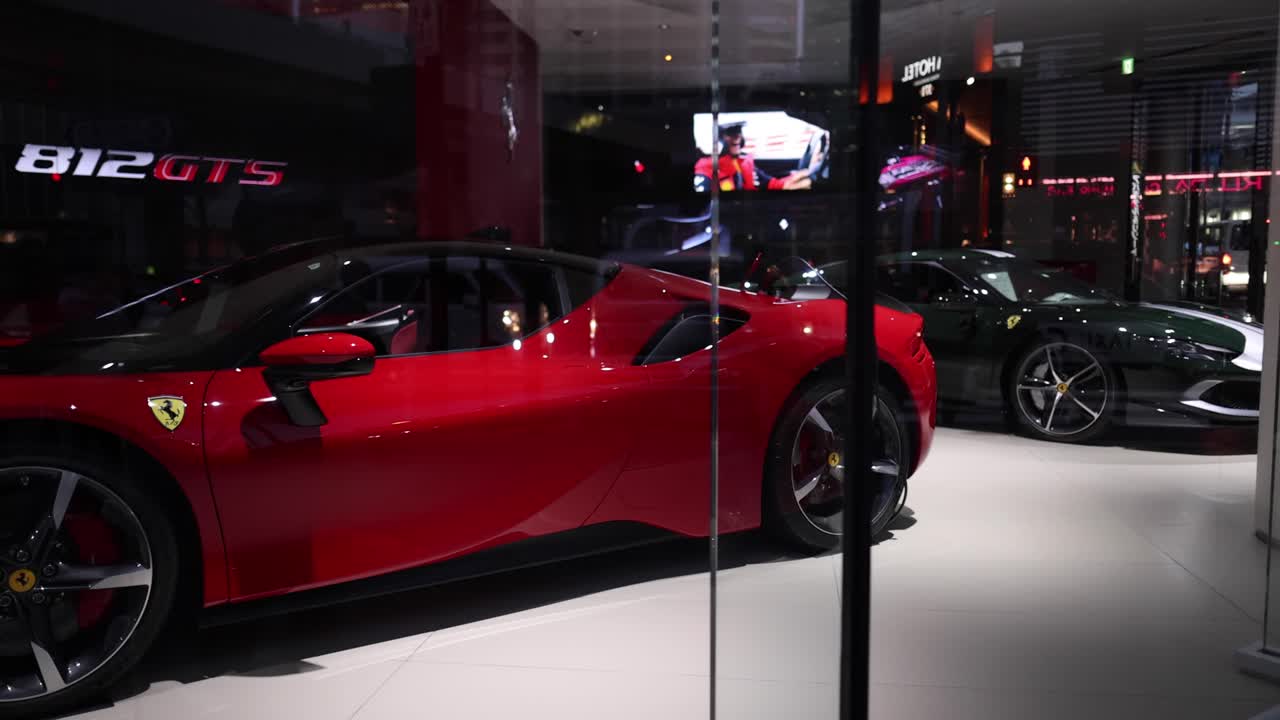 un coche deportivo rojo giratorio en una sala de exhibición de lujo