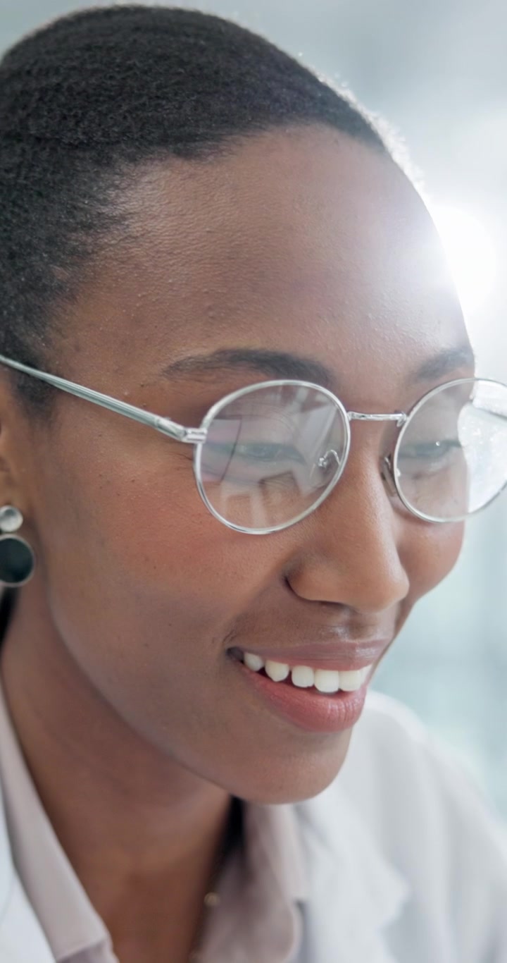 Professional Woman Putting On Glasses in Bright Office