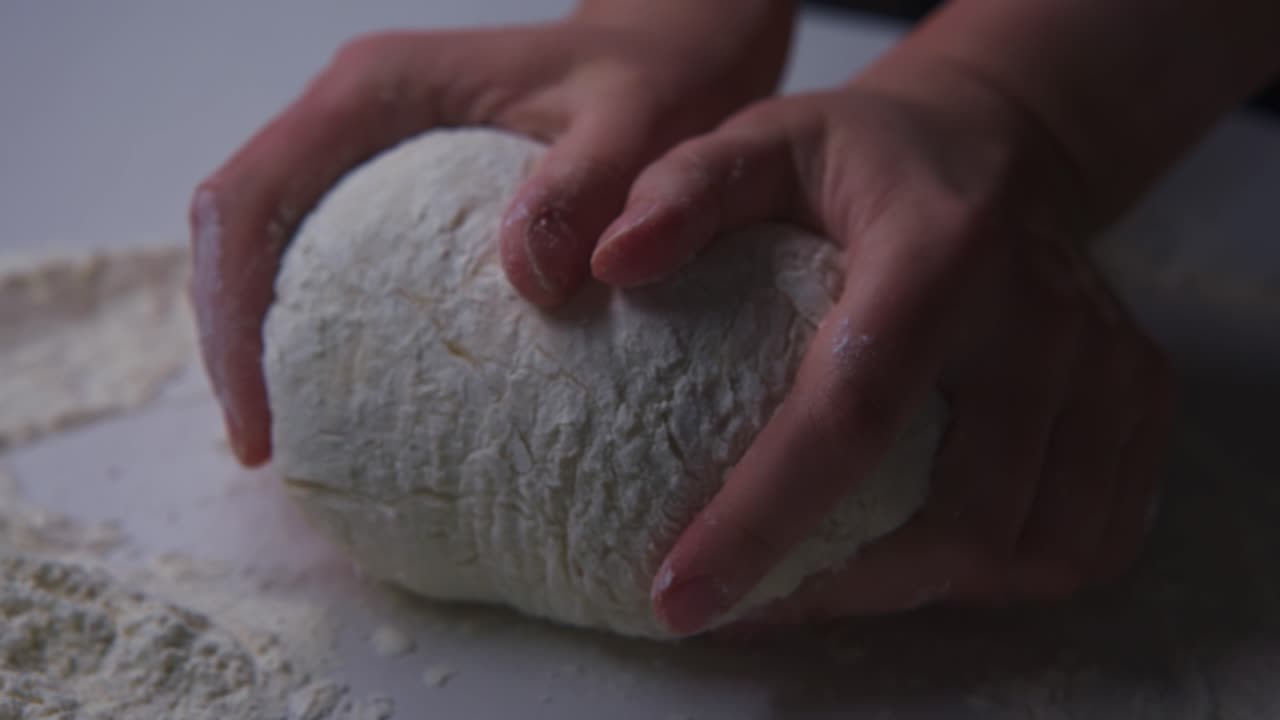 Close-Up of Hands Kneading Dough with Flour