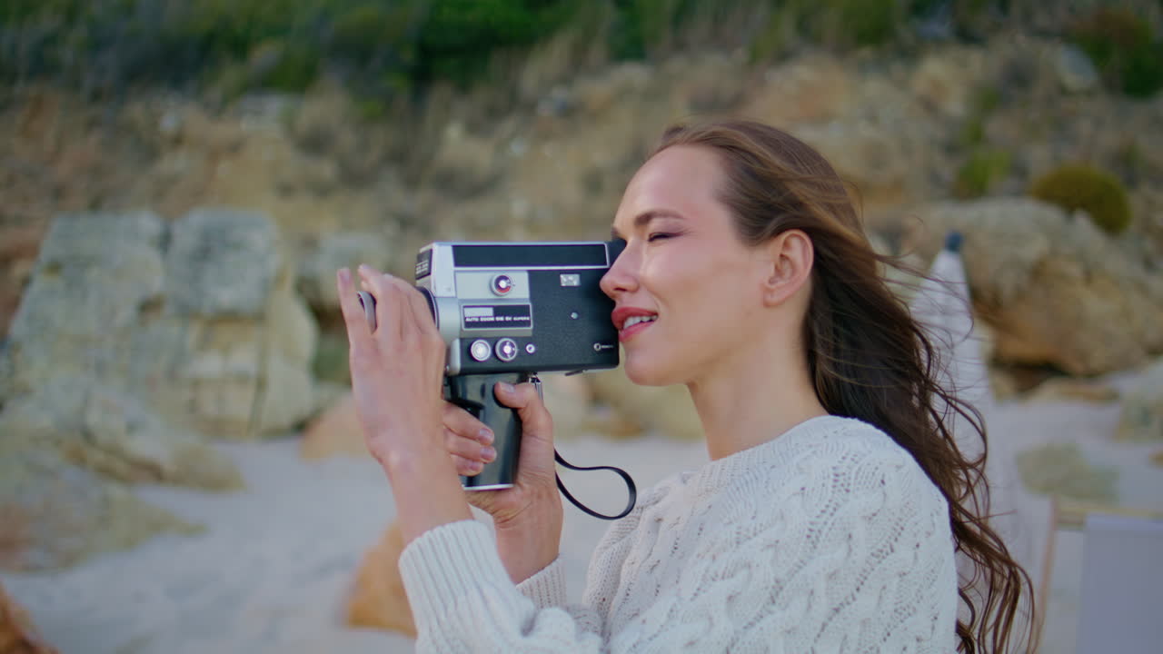 Nature explorer filming landscape on retro video camera at windy weather closeup