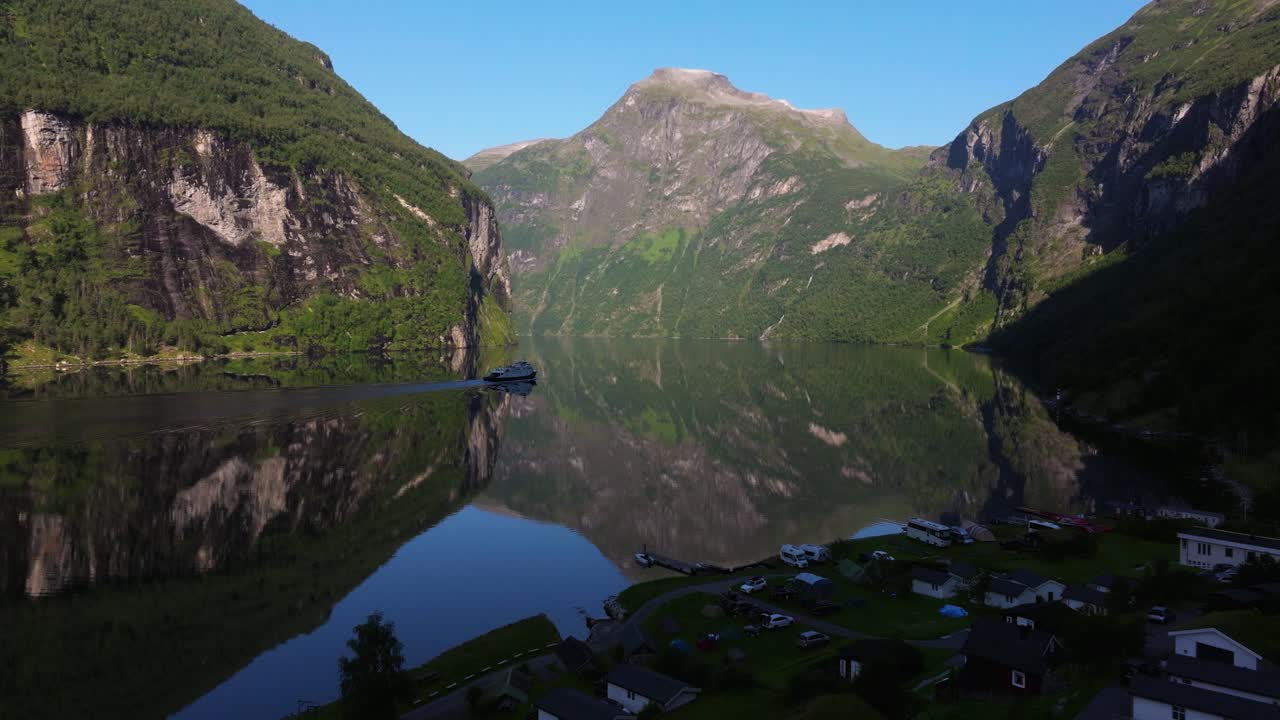 vista aérea sobre las cabañas en geirangerfjord mientras el ferry trae turistas en un crucero por el fiordo de geiranger a hellesylt, noruega