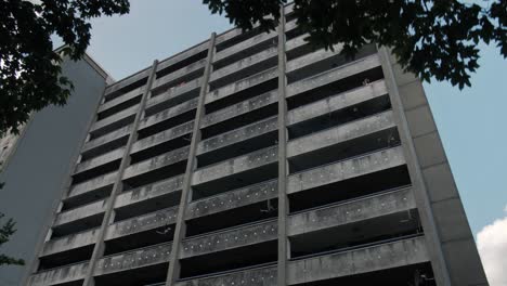 slow motion reveal of an aged residential high-rise in a low-income area with satellite dishes