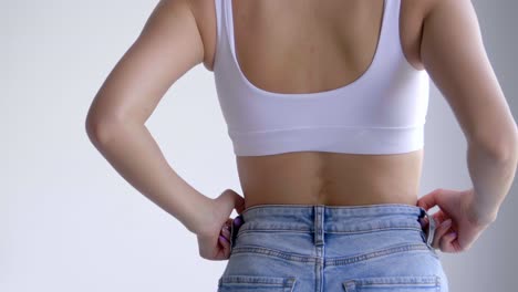 Rear-View-Of-A-Woman-With-Slim-Figure-Wearing-Sports-Bra-And-Denim