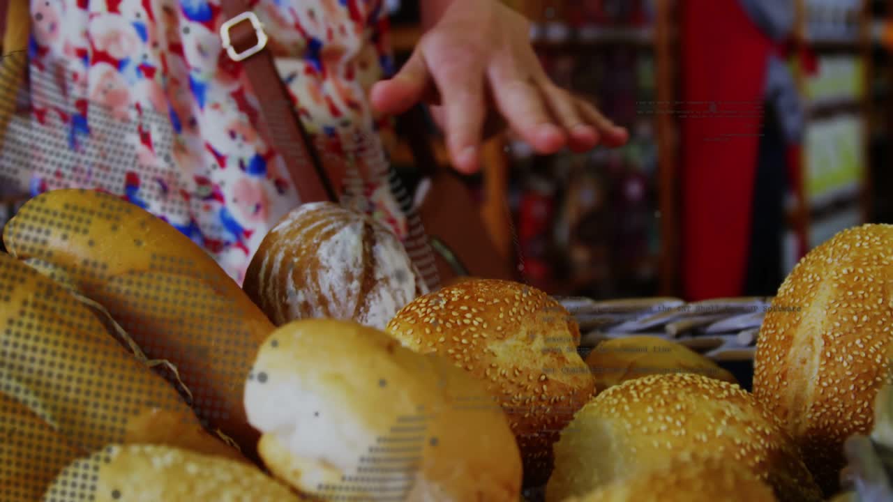 Foreground bread basket, shopper hand moving down above, touching seeded rolls, selecting, buying