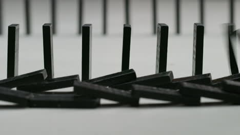 rows of black dominoes in a white studio