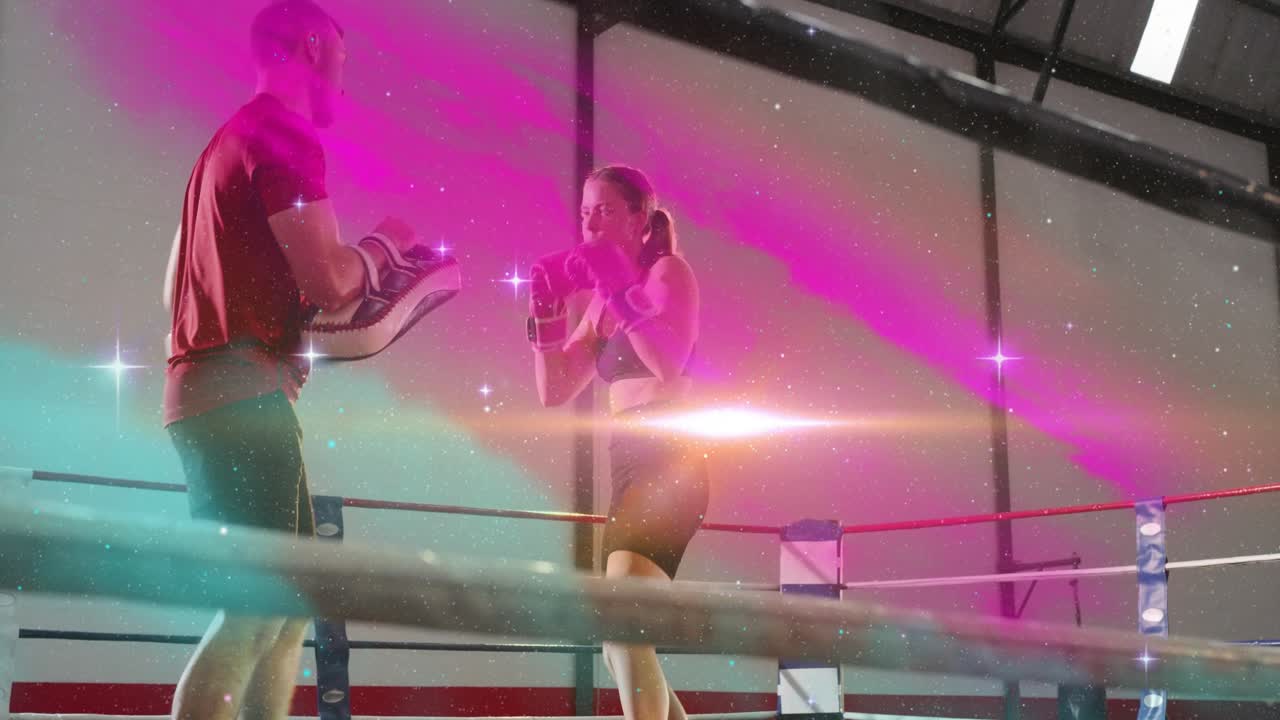 Coach raising mitts, trainee throwing combos for timing in boxing drill, pink-teal filter over ring