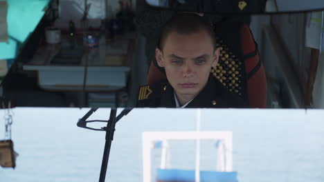 a young officer or sailor on a ship's bridge