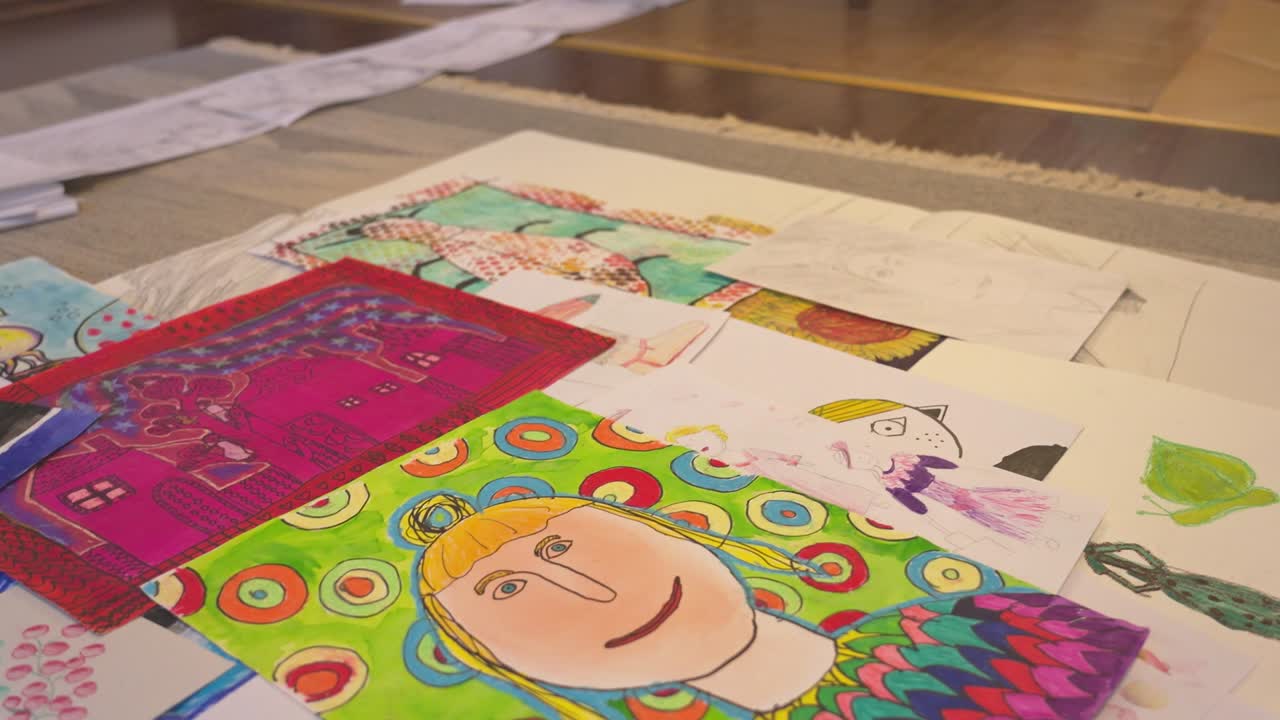 colección de pinturas coloridas, incluyendo arte abstracto y retratos, esparcidas en el suelo