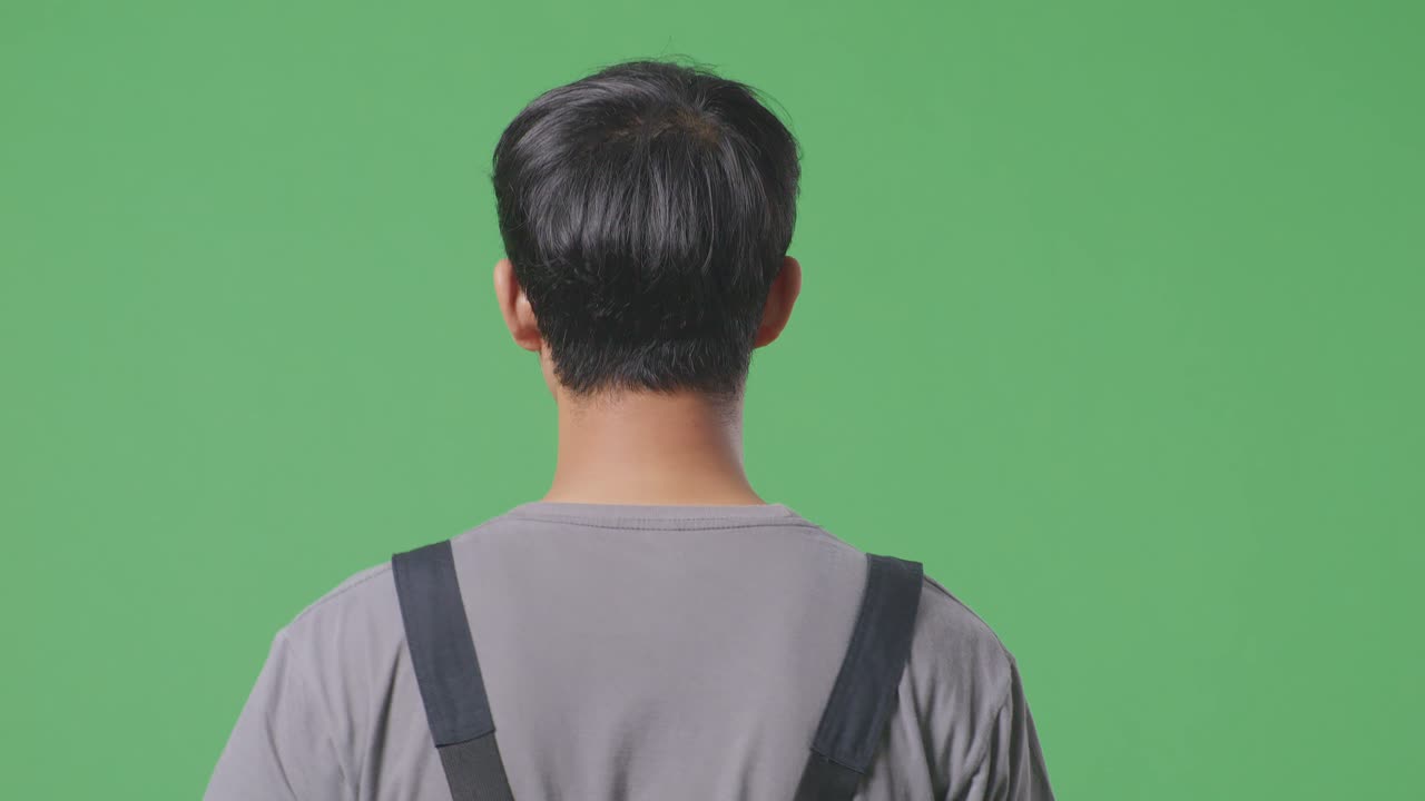 녹색 스크린 배경 스튜디오에서 걸어가는 아시아 남성 노동자