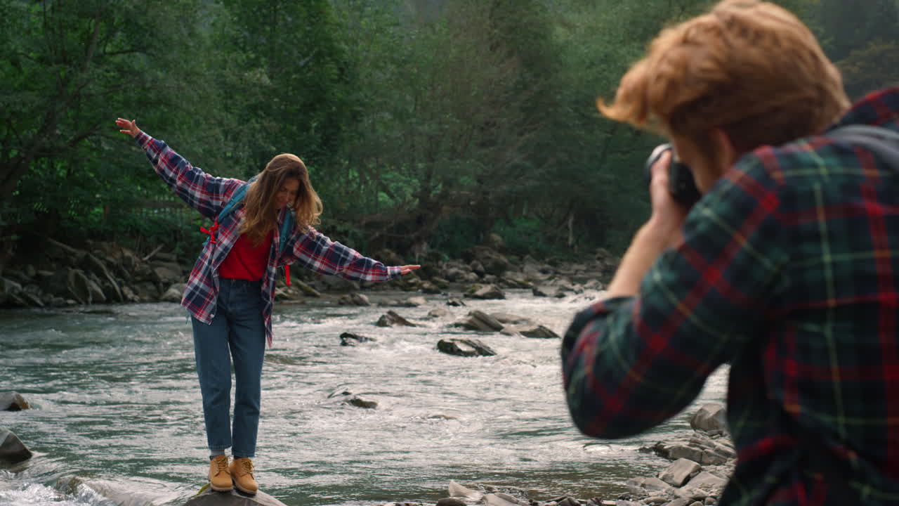 fotógrafo fotografiando a una mujer en el río. chica haciendo una mueca divertida en la cámara