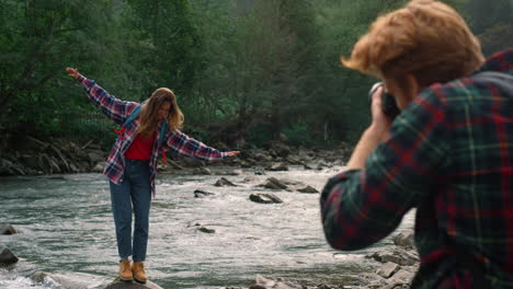 photographer photographing woman at river. girl making funny grimace at camera