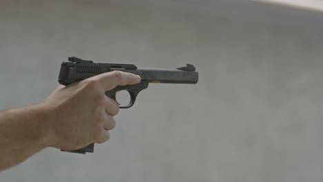 shooter securely firing a small caliber shot and placing his finger above the pistol trigger