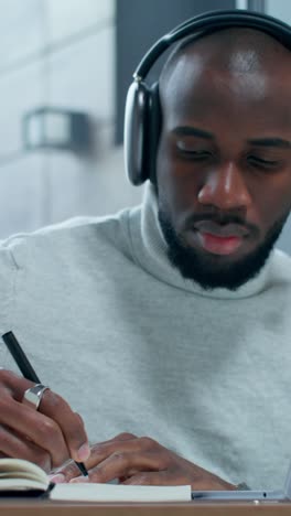focused man taking notes on a laptop