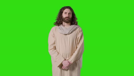 portrait shot of man wearing robes with long hair and beard representing figure of jesus christ on green screen