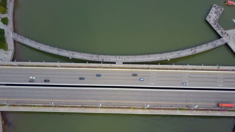 aerial of cars driving on a bridge near river