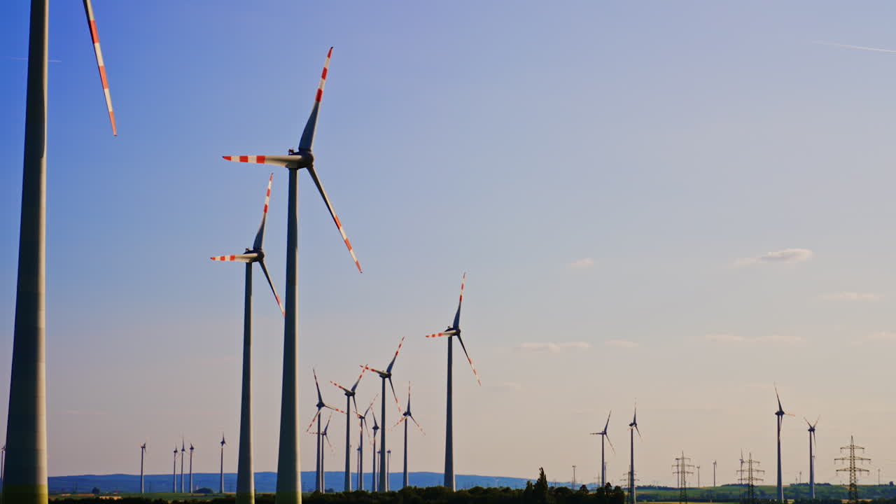 Daylight wind turbines create energy. Rows of wind turbines harnessing wind energy under a clear blue sky, showcasing renewable energy innovation