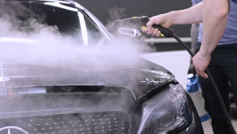 hombre que cubre el coche con cinta de poliuretano de vinilo. películas para el coche. pegatina película protectora en el coche