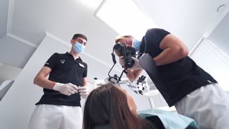 dentist making shots of patient. male dentist photographing teeth of patient
