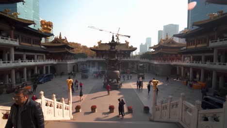 tourists walking on main square of jing'an temple in shanghai, china.