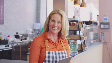 portrait of female owners or workers in coffee shop or restaurant using digital tablet