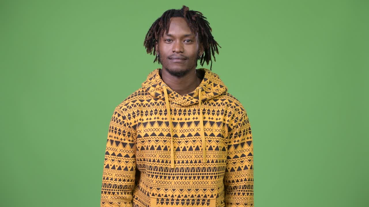 Giovane e affascinante uomo africano che si copre la bocca mentre sembra colpevole.