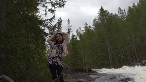 woman plays by a crazy river in the forest