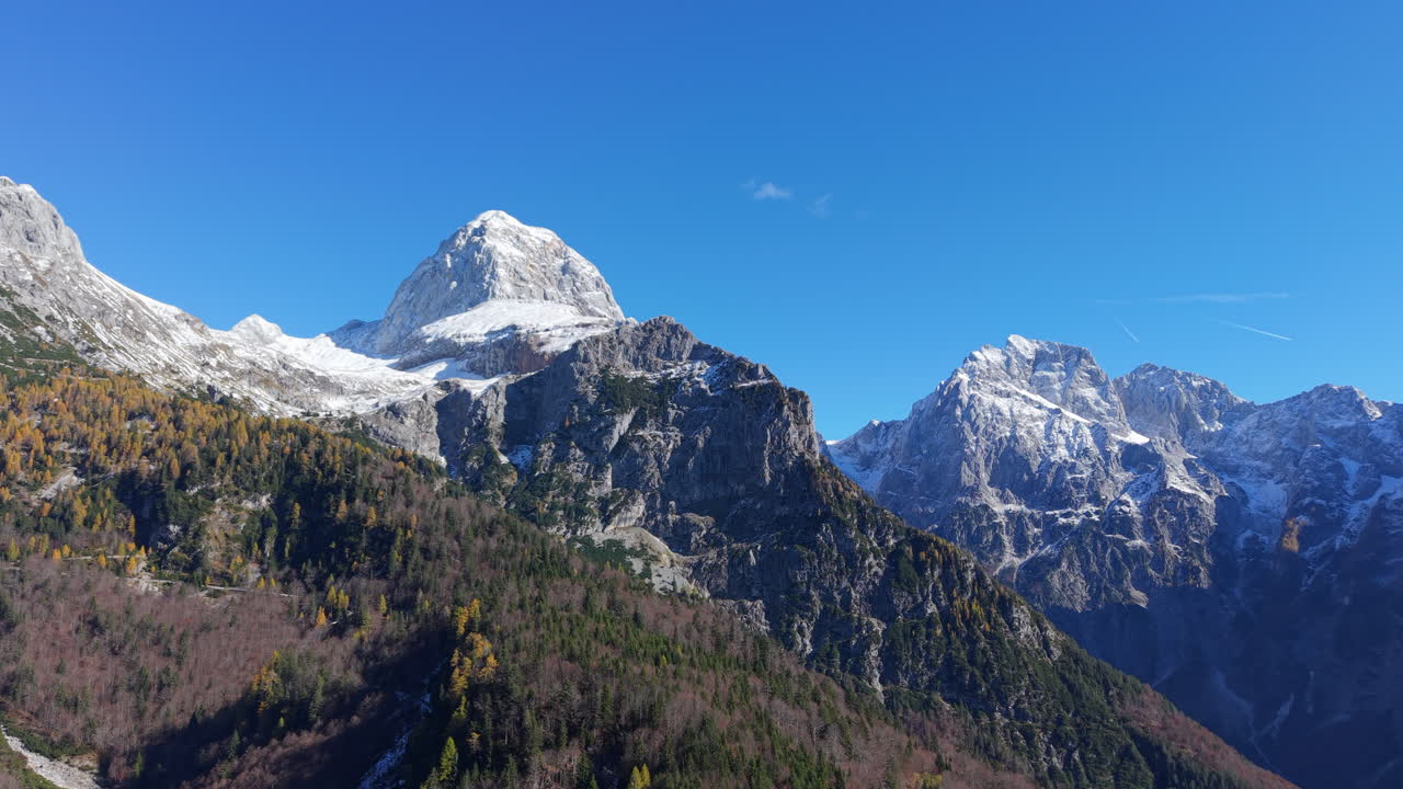 Majestic aerial view of the snow capped Julian Alps in Slovenia during a sunny autumn day