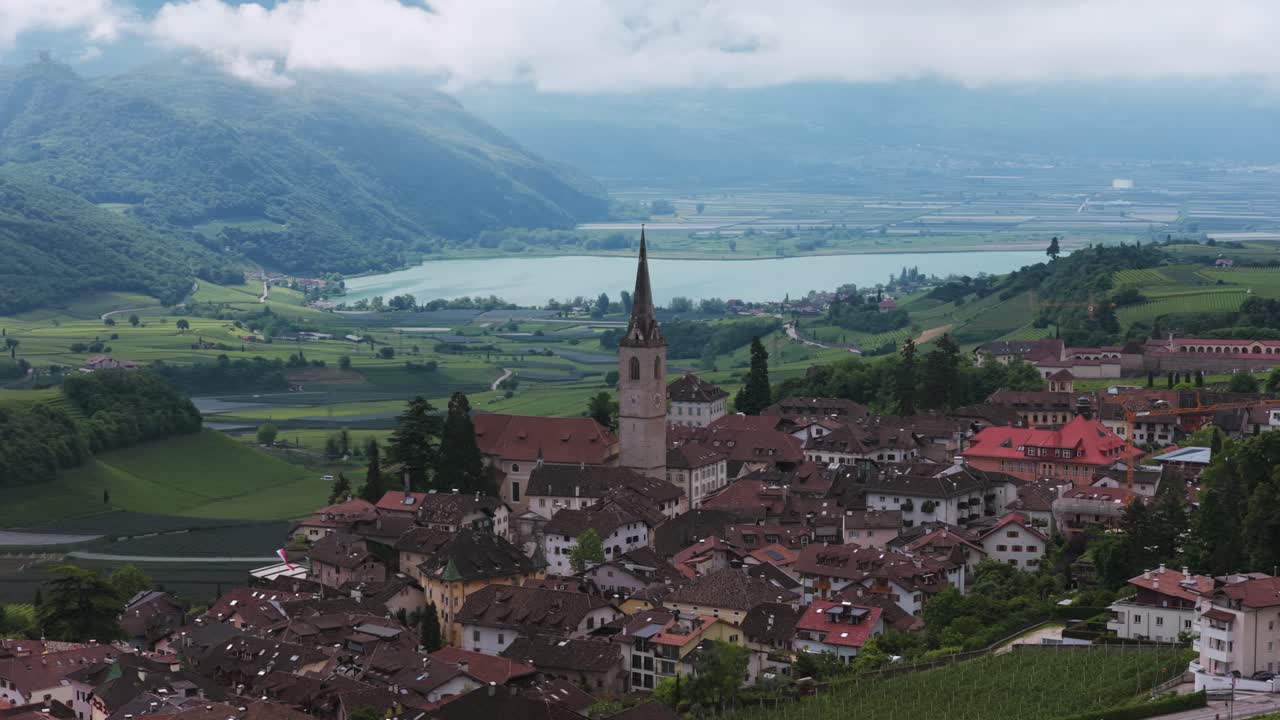 Aerial view of Caldaro sulla Strada del Vino with Caldaro Parish Church, vineyards, and Lake Caldaro, Italy. Circle Dolly
