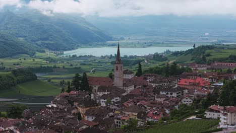 aerial view of caldaro sulla strada del vino with caldaro parish church, vineyards, and lake caldaro, italy. circle dolly