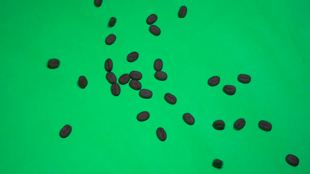 chicchi di caffè che cadono nella vista del primo piano della croma della priorità bassa