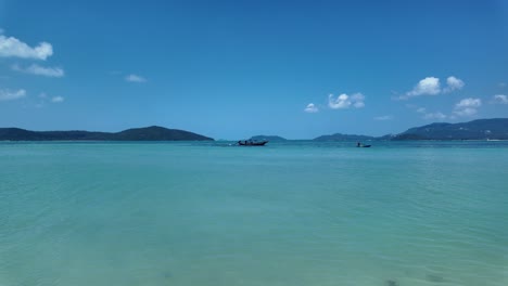 Toma-Estática-Del-Vasto-Océano-Azul-Mientras-Los-Lugareños-Cruzan-El-Marco-En-Barcos-De-Pesca,-Tailandia-Durante-El-Día