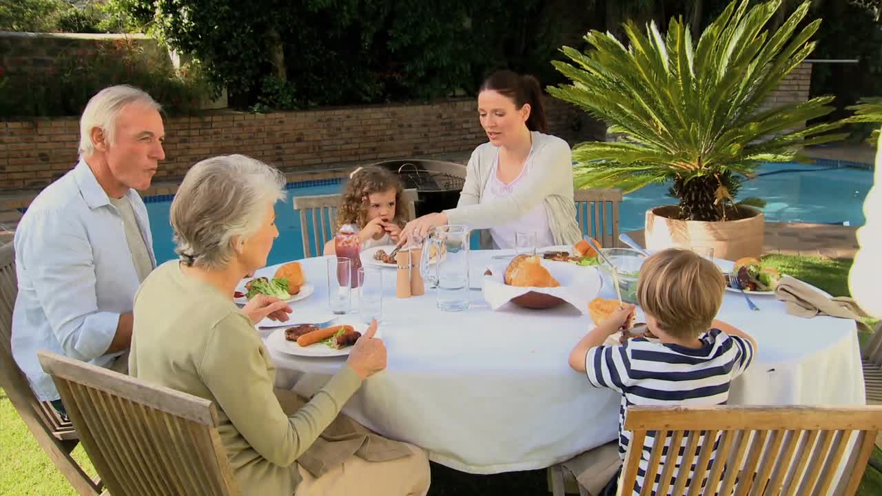 gran familia teniendo una barbacoa en el jardín