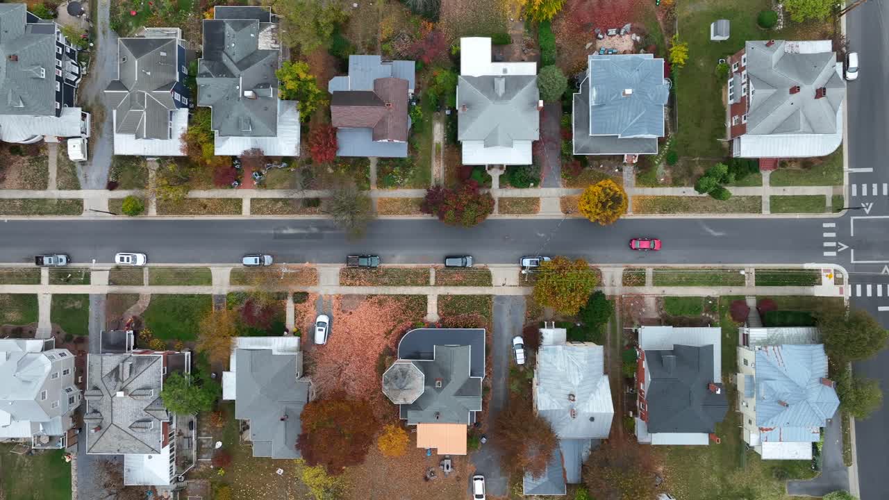 Bird's-eye view of a residential street with houses and autumn trees