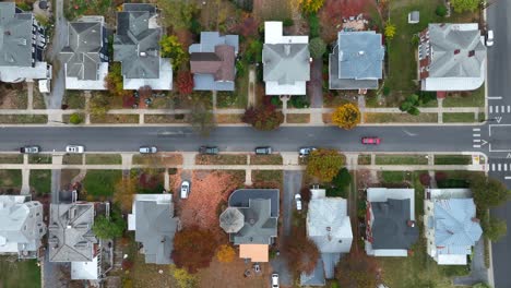 Bird&#039;s-eye view of a residential street with houses and autumn trees