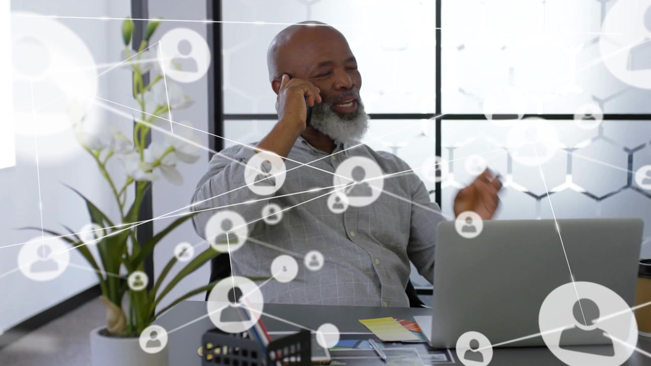 Animation of network of profile icons over african american man talking on smartphone at office