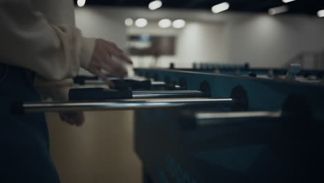 Girl-hands-grasping-table-football-rods-close-up.-Schoolgirl-enjoy-soccer-match.