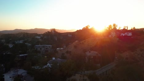 Slow-rise-up-above-the-Hollywood-Hills-to-reveal-the-sun-with-lens-flare