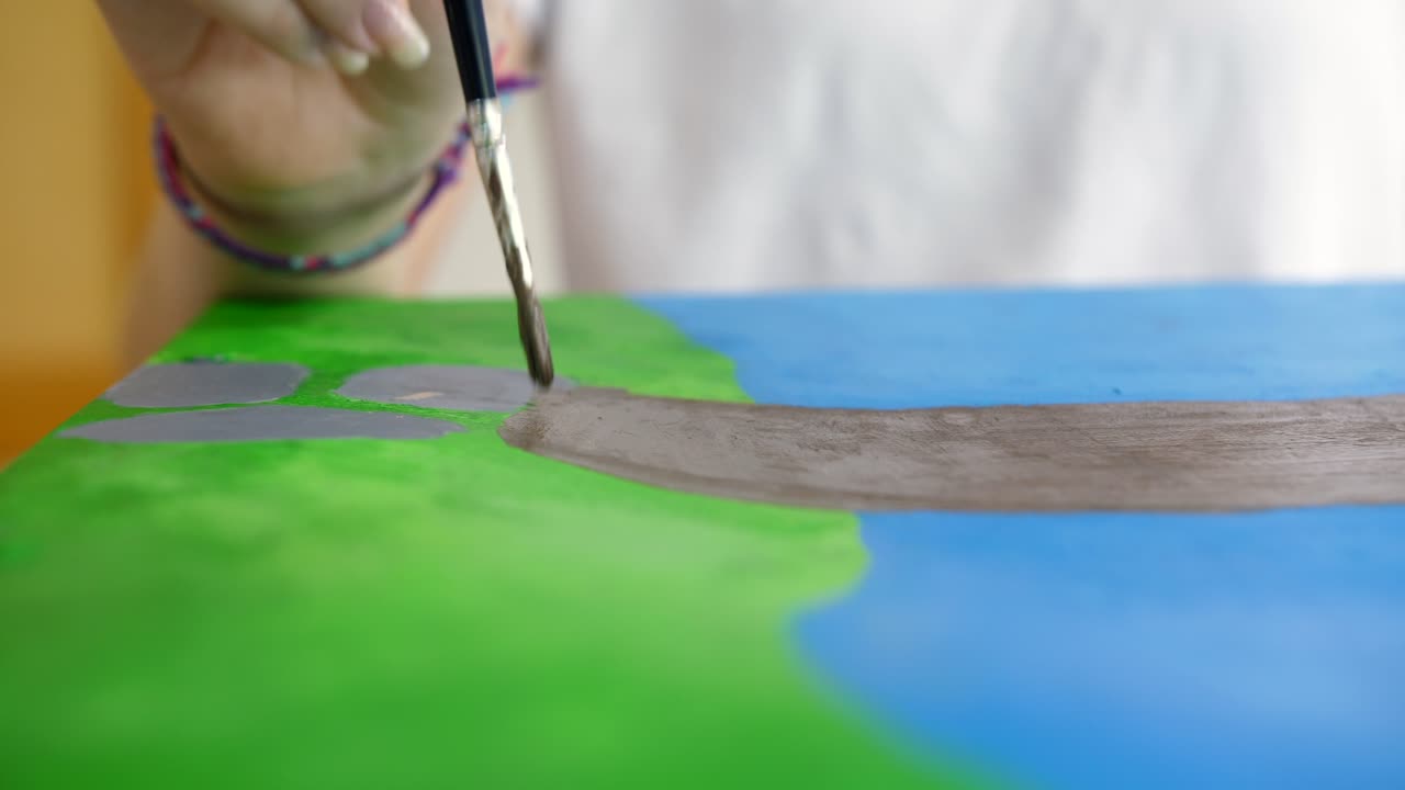 손으로 수채화 그림 그림으로 그리는 어린 소녀의 세부 샷