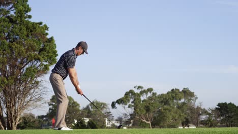 golf player hitting the ball with his club