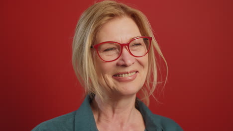 retrato de una mujer mayor positiva en fondo rojo