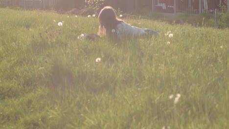 woman relaxing in summer meadow reading a book