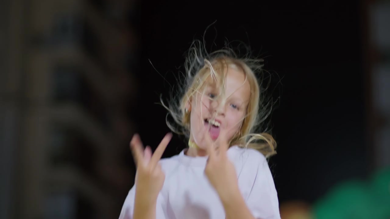 Young Girl Jumping and Making Funny Faces at Night