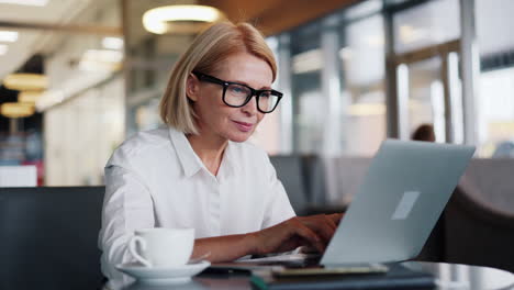 woman working on laptop in cafe
