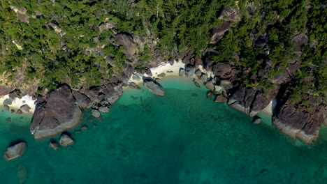 epic revealing drone shot of rocks and beach at hook island near whitsunday australia