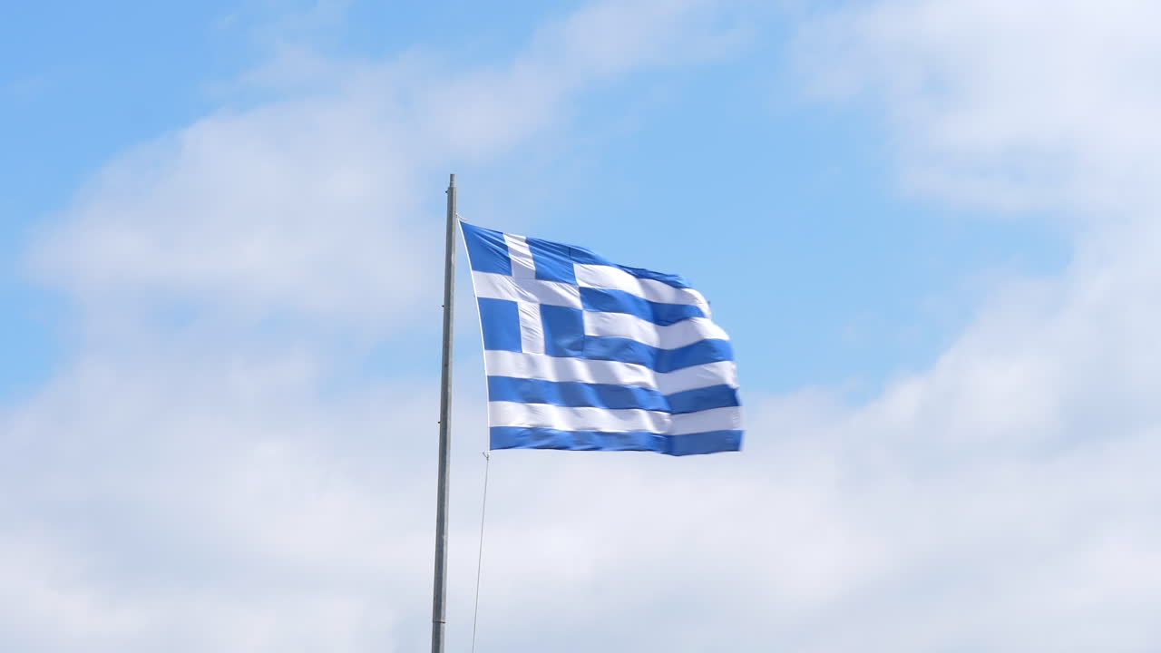 bandera de grecia en el viento, nubes blancas fondo de cielo soleado 4k