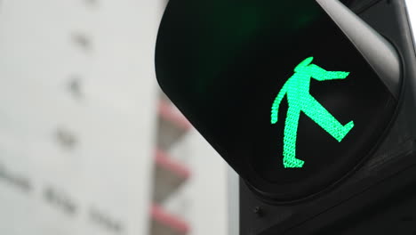 green signal light with a building in a background