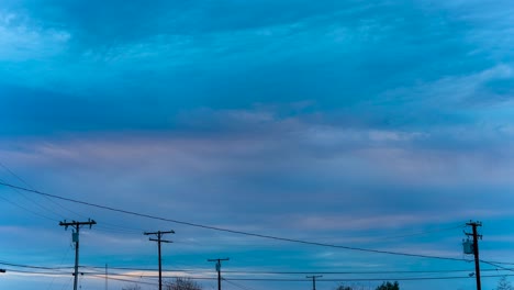 paisaje nublado al atardecer sobre un barrio suburbano con espacio de copia sobre los cables de servicios públicos y postes de teléfono - lapso de tiempo