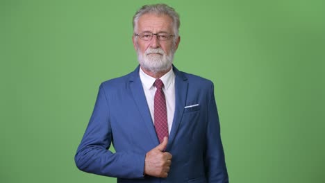 hombre de negocios barbudo y guapo contra un fondo verde.
