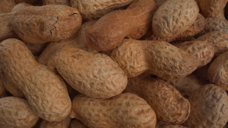 peanuts in shells macro moving, food product used in recipes like chocolates, sauces and oils, known allergen, healthy nuts, peanut allergy, 4k shot